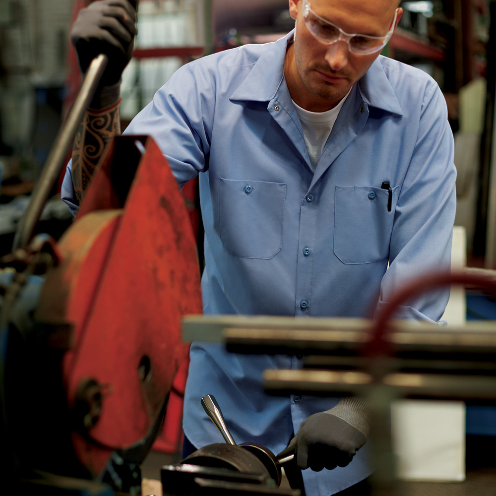 Manufacturing worker wearing light blue Dempsey Uniform work shirt