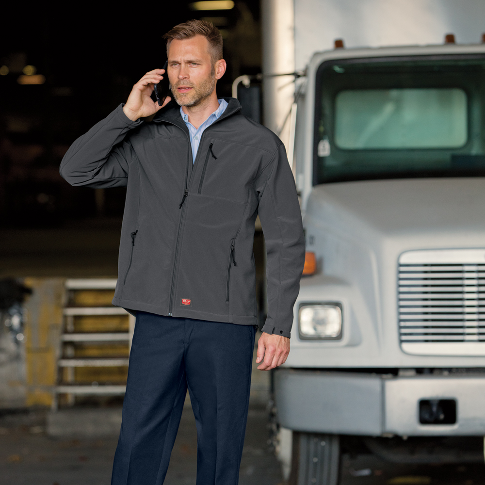 Worker on the phone outside his truck wearing a Dempsey Uniform soft-shell jacket