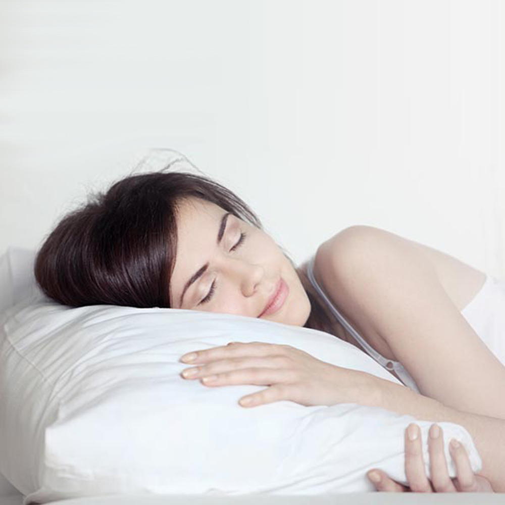 Woman sleeping on Dempsey Uniform standard bed linens