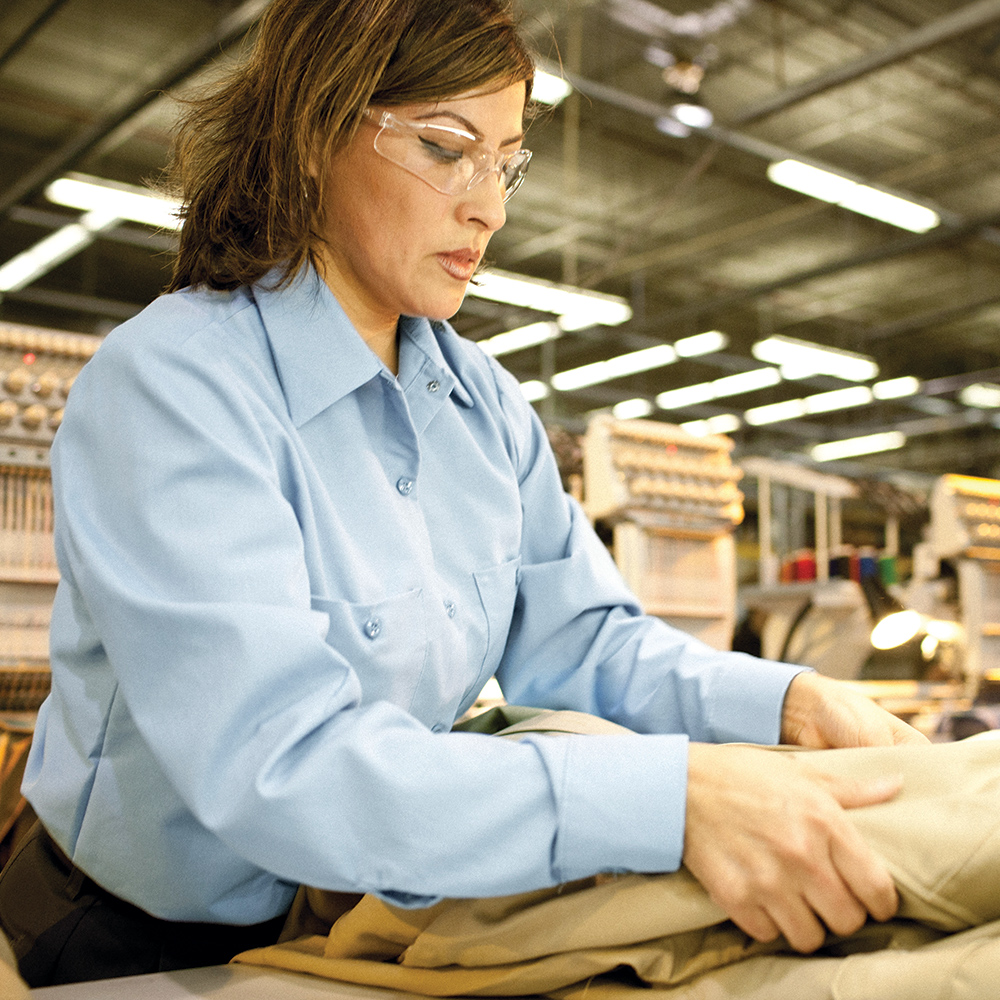 Warehouse worker wearing a light blue Dempsey Uniform womens long sleeve work shirt