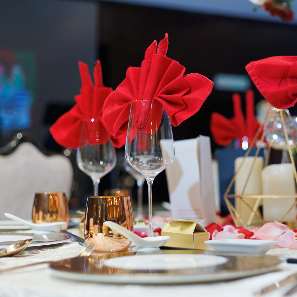 Red Dempsey Uniform cloth napkins artfully displayed in wine glasses in place settings